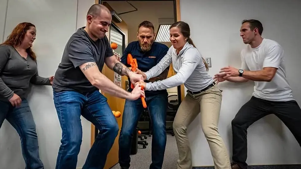 A student practices a self-defense technique with an instructor